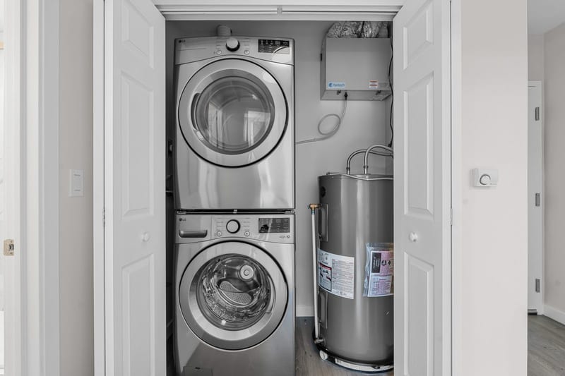 The laundry closet: a stacked washer and dryer, and the water heater